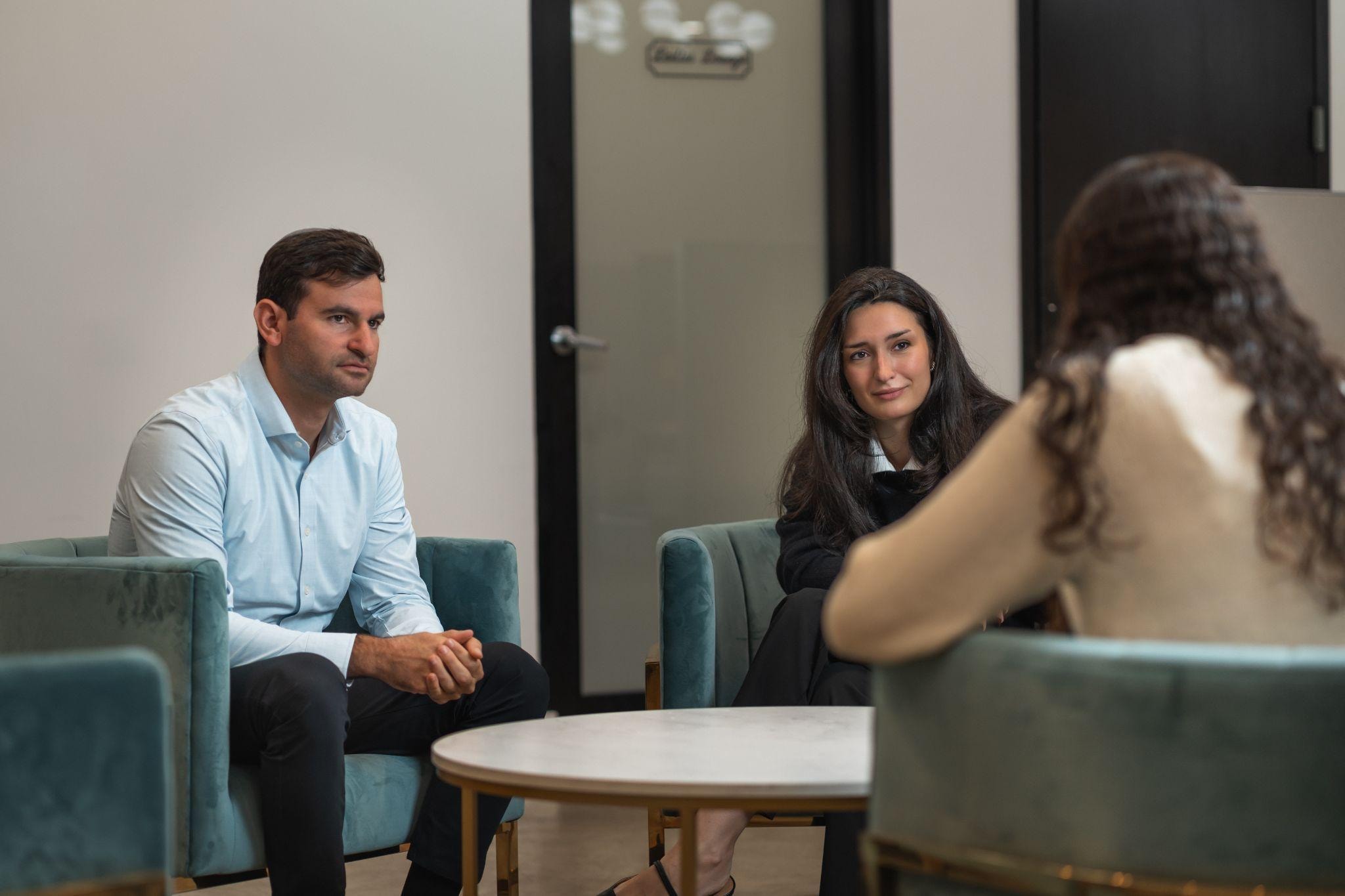 A couple sitting with their therapist during a therapy session